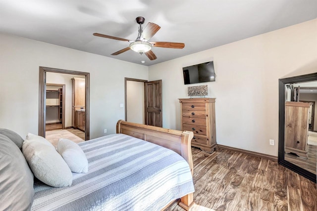 1830 Pine Tree Ct, Luxemburg, WI 54217 - bedroom with light wood-style floors, baseboards, a ceiling fan, and connected bathroom
