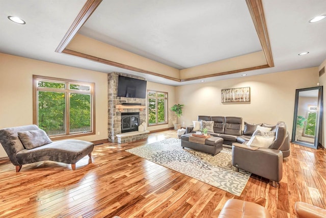 1830 Pine Tree Ct, Luxemburg, WI 54217 - living area with a tray ceiling, light wood finished floors, a fireplace, recessed lighting, and baseboards