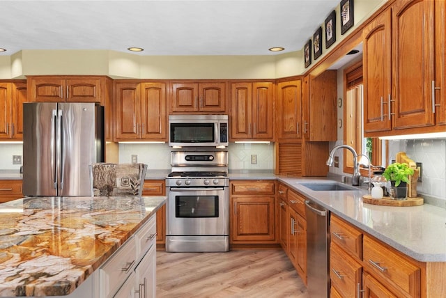 N2068 Alphorn Rd, Monroe, WI 53566 - kitchen with appliances with stainless steel finishes, light stone counters, light wood-type flooring, brown cabinetry, and recessed lighting