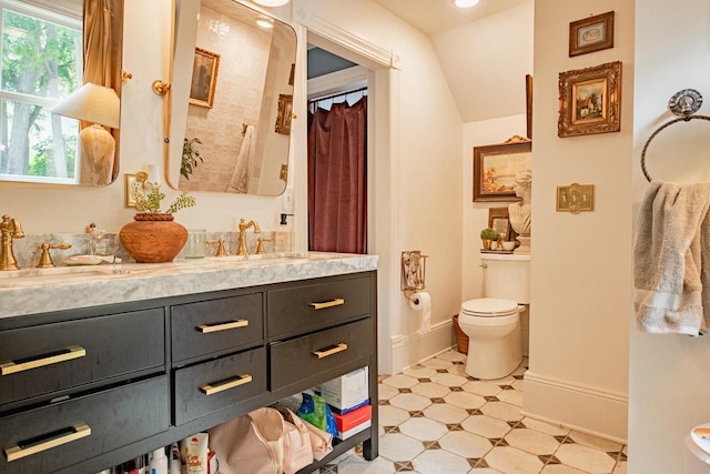 72 W Mill St, Winona, MN 55987 - bathroom featuring toilet, double vanity, baseboards, and tile patterned floors