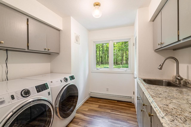 1418 Mill Rd, Delafield, WI 53018 - washroom with baseboard heating, washer and dryer, wood finished floors, cabinet space, and baseboards