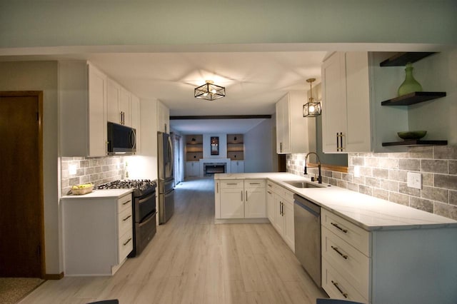 11426 W Woods Rd, Franklin, WI 53132 - kitchen with appliances with stainless steel finishes, a sink, white cabinets, light wood-type flooring, and tasteful backsplash