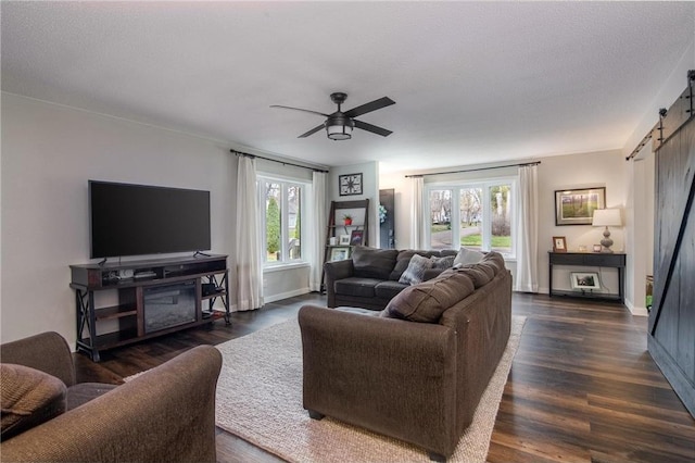 222 1st Ave, Clear Lake, WI 54005 - living room featuring a barn door, a ceiling fan, dark wood-style floors, and baseboards