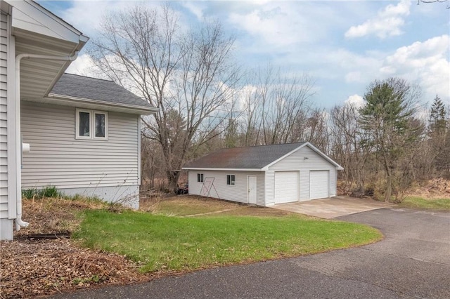 222 1st Ave, Clear Lake, WI 54005 - view of side of home featuring an outdoor structure, a detached garage, a yard, and roof with shingles