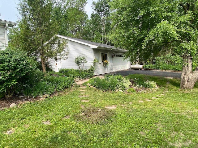 8001 Waschbisch Rd, Oconto Falls, WI 54154 - view of home's exterior with asphalt driveway, a garage, and a yard