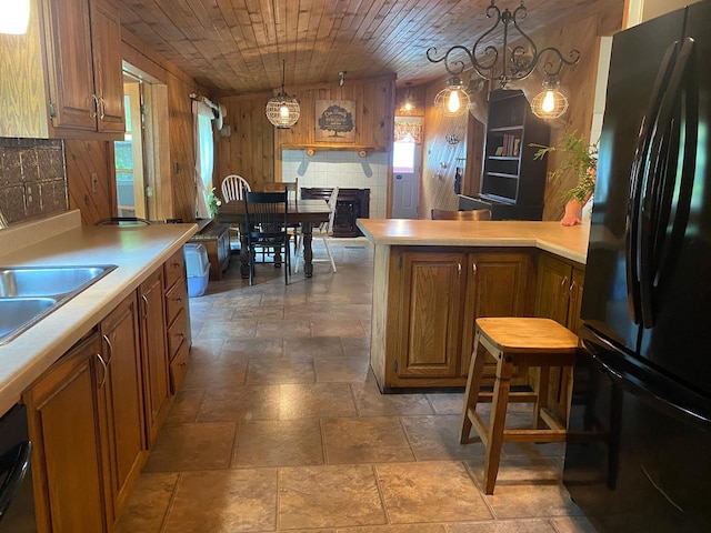 8001 Waschbisch Rd, Oconto Falls, WI 54154 - kitchen featuring black appliances, wooden walls, light countertops, wooden ceiling, and brown cabinets