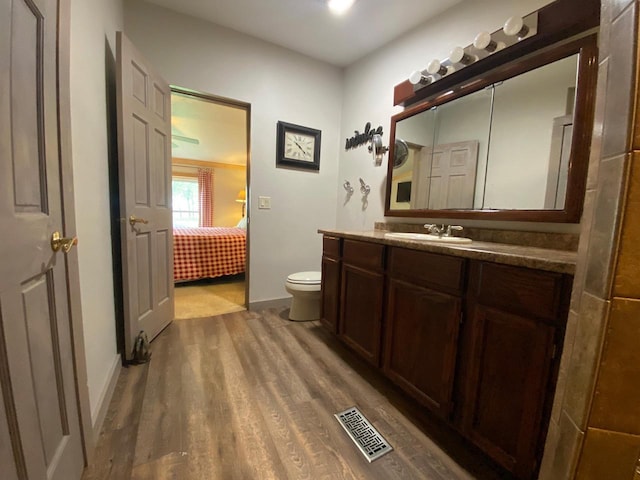 8001 Waschbisch Rd, Oconto Falls, WI 54154 - bathroom with wood finished floors, toilet, vanity, and baseboards