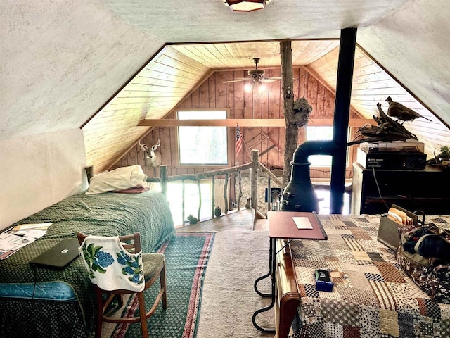 16651 Dolittle Ln, Townsend, WI 54175 - bedroom with lofted ceiling, wooden walls, and a wood stove