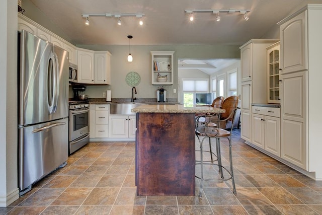 N5071 Deer Trl, Marinette, WI 54143 - kitchen with stainless steel appliances, a sink, vaulted ceiling, a center island, and a kitchen breakfast bar