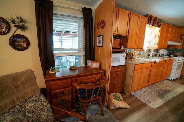 134 Attewell St Unit 54, Mauston, WI 53948 - kitchen with white appliances, dark wood finished floors, a sink, brown cabinets, and under cabinet range hood