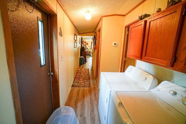 134 Attewell St Unit 54, Mauston, WI 53948 - washroom with separate washer and dryer, light wood-style flooring, cabinet space, a textured ceiling, and crown molding