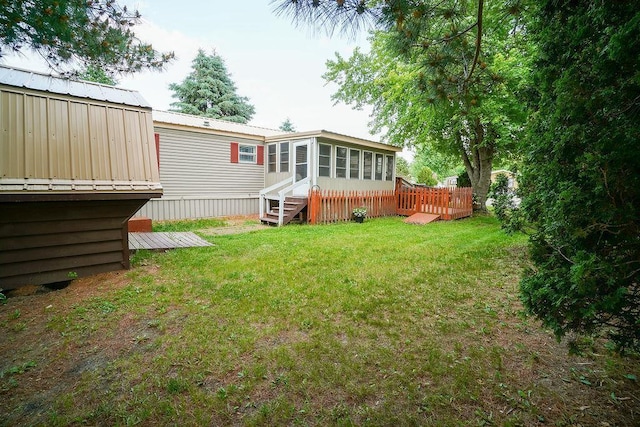 134 Attewell St Unit 54, Mauston, WI 53948 - back of house featuring a sunroom, a deck, a yard, and metal roof