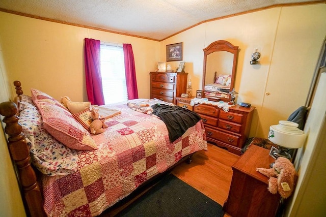 134 Attewell St Unit 54, Mauston, WI 53948 - bedroom featuring ornamental molding, vaulted ceiling, a textured ceiling, and wood finished floors