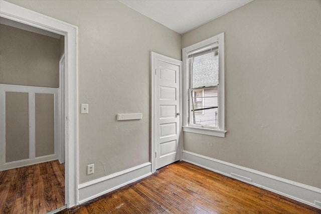 1718 W Washington St Unit 1720, Milwaukee, WI 53204 - unfurnished bedroom featuring wood finished floors, multiple windows, and baseboards