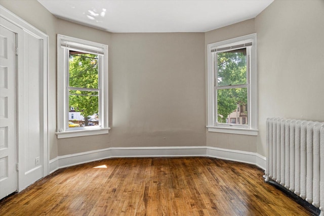 1718 W Washington St Unit 1720, Milwaukee, WI 53204 - unfurnished bedroom with radiator, wood-type flooring, and baseboards