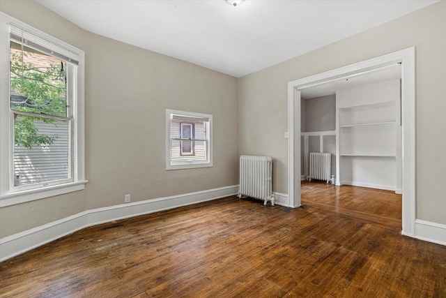 1718 W Washington St Unit 1720, Milwaukee, WI 53204 - unfurnished bedroom featuring radiator heating unit, wood finished floors, and baseboards