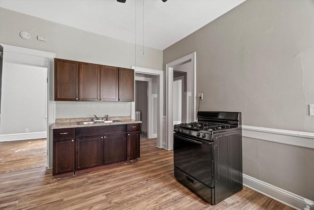 1718 W Washington St Unit 1720, Milwaukee, WI 53204 - kitchen with black gas range, a sink, wood finished floors, dark brown cabinets, and light countertops