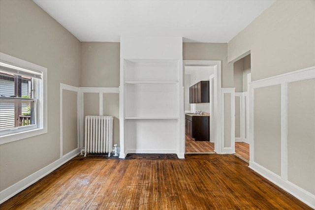 1718 W Washington St Unit 1720, Milwaukee, WI 53204 - unfurnished bedroom with radiator heating unit, dark wood-style floors, and a sink