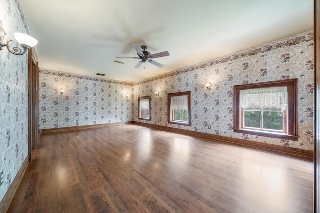 4760 State Rd 91, Oshkosh, WI 54904 - spare room with wallpapered walls, wood finished floors, ceiling fan, and baseboards