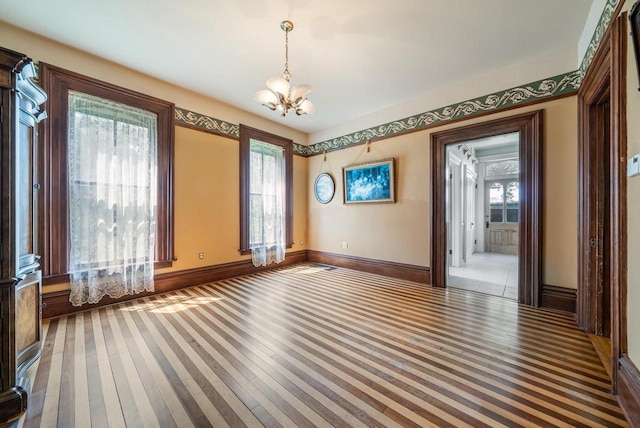 4760 State Rd 91, Oshkosh, WI 54904 - unfurnished room with a chandelier, wood-type flooring, and baseboards