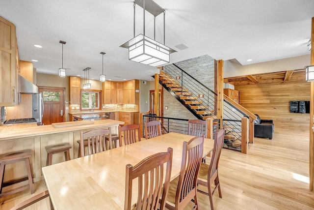 3857 Lake Lucerne Dr, Crandon, WI 54520 - dining room with light wood finished floors, stairs, recessed lighting, and wood walls