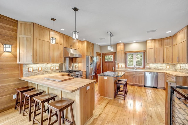 3857 Lake Lucerne Dr, Crandon, WI 54520 - kitchen featuring stainless steel appliances, under cabinet range hood, butcher block counters, a kitchen breakfast bar, and a sink