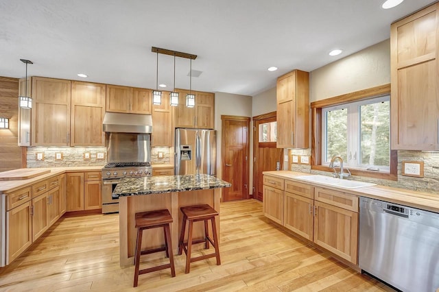 3857 Lake Lucerne Dr, Crandon, WI 54520 - kitchen with appliances with stainless steel finishes, a sink, under cabinet range hood, a center island, and light wood finished floors