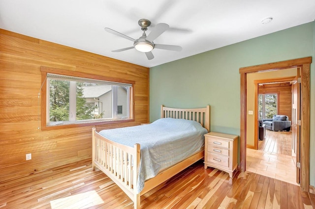 3857 Lake Lucerne Dr, Crandon, WI 54520 - bedroom with wooden walls, light wood-type flooring, and a ceiling fan