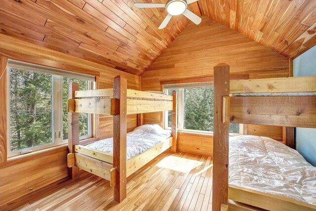 3857 Lake Lucerne Dr, Crandon, WI 54520 - bedroom featuring lofted ceiling, wood ceiling, multiple windows, wooden walls, and hardwood / wood-style floors