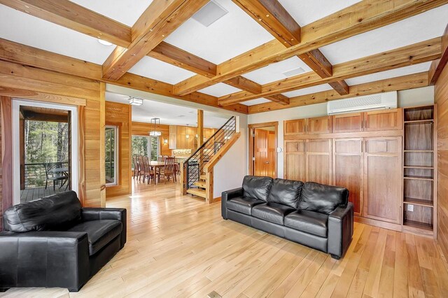 3857 Lake Lucerne Dr, Crandon, WI 54520 - living area featuring an AC wall unit, beam ceiling, light wood-type flooring, wood walls, and stairs