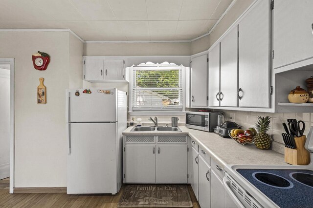 547 Eureka St, Ripon, WI 54971 - kitchen with white appliances, a sink, wood finished floors, light countertops, and white cabinetry