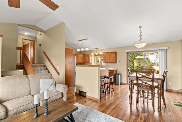 7338 Blue Maple Trl, Madison, WI 53719 - living area with vaulted ceiling, ceiling fan, light wood-style flooring, baseboards, and stairs