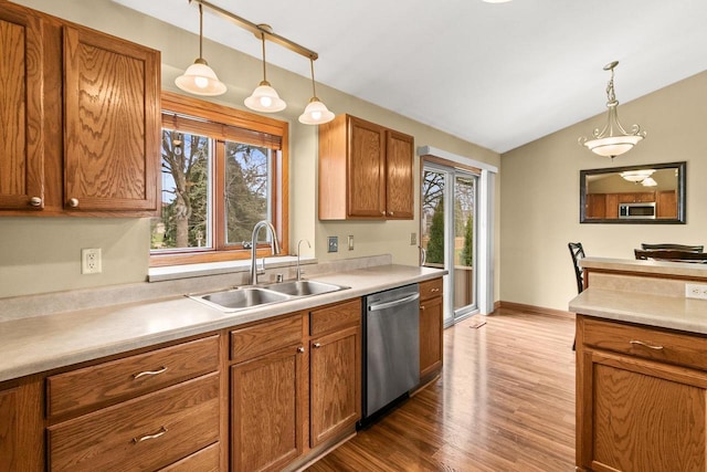 7338 Blue Maple Trl, Madison, WI 53719 - kitchen featuring appliances with stainless steel finishes, a sink, wood finished floors, lofted ceiling, and plenty of natural light