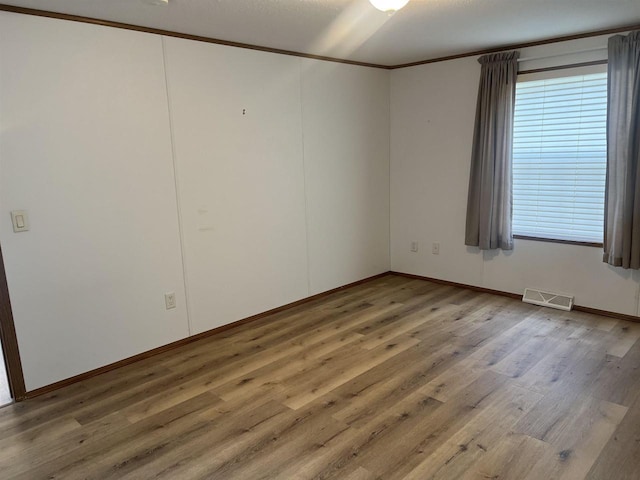N2639 County Road Z Unit B19, Dousman, WI 53118 - empty room featuring wood finished floors, baseboards, and crown molding