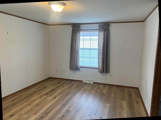 N2639 County Road Z Unit B19, Dousman, WI 53118 - empty room featuring wood finished floors, crown molding, and baseboards