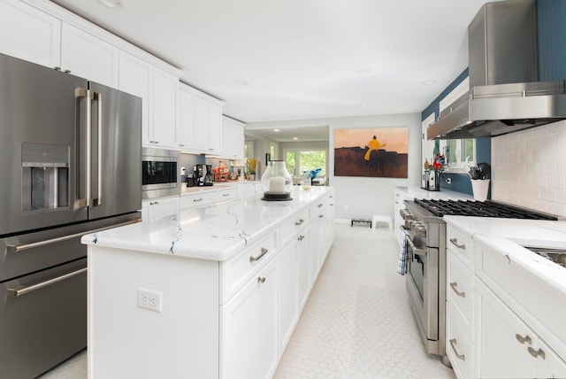 W347N6122 Rd I, Oconomowoc, WI 53066 - kitchen with high quality appliances, island exhaust hood, a kitchen island, light stone countertops, and backsplash
