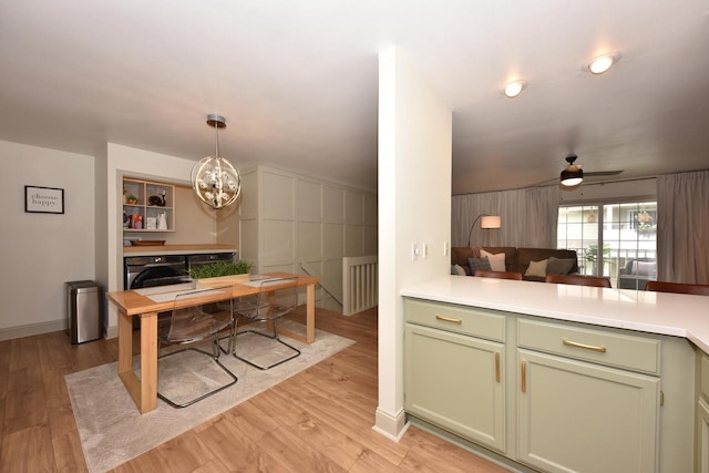 724 Worthington Ct Unit 3-A, West Bend, WI 53090 - kitchen featuring green cabinetry, a chandelier, light wood-type flooring, and washer / clothes dryer