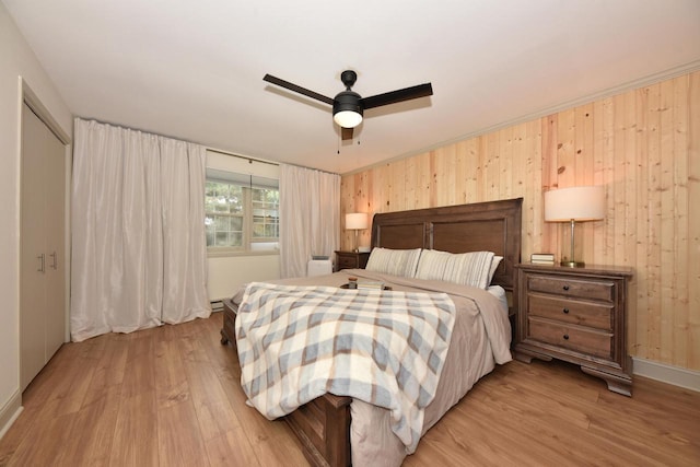 724 Worthington Ct Unit 3-A, West Bend, WI 53090 - bedroom with light wood-style flooring, wooden walls, a ceiling fan, and baseboards