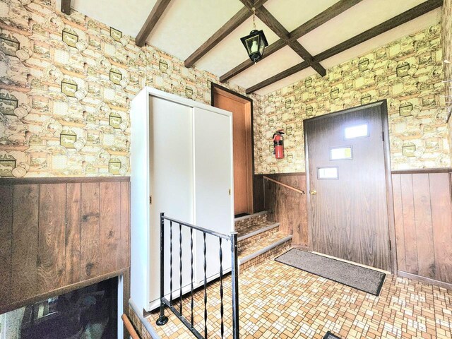5609 Two Creeks Rd, Two Rivers, WI 54241 - entrance foyer with a wainscoted wall, wood walls, beamed ceiling, and stairs