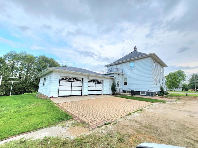 5609 Two Creeks Rd, Two Rivers, WI 54241 - back of property with a lawn, a balcony, a detached garage, and a chimney