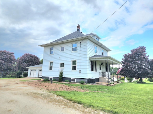 5609 Two Creeks Rd, Two Rivers, WI 54241 - back of house with a chimney, a yard, a garage, cooling unit, and a shingled roof