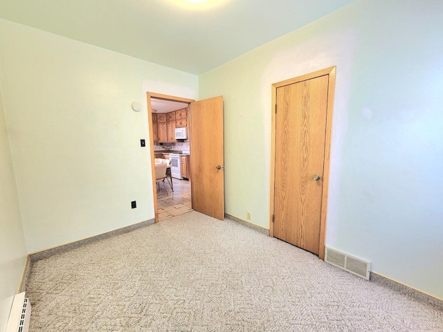 5609 Two Creeks Rd, Two Rivers, WI 54241 - unfurnished room featuring a baseboard radiator, light carpet, and baseboards
