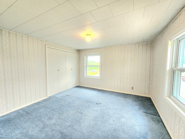 5609 Two Creeks Rd, Two Rivers, WI 54241 - unfurnished bedroom with carpet floors, a closet, and wallpapered walls