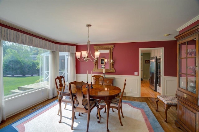 101 Everglade Dr, Madison, WI 53717 - dining room with a chandelier, wood finished floors, wainscoting, and ornamental molding