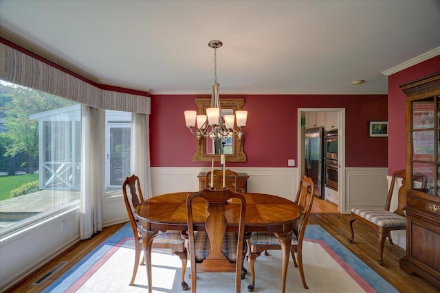 101 Everglade Dr, Madison, WI 53717 - dining area featuring a chandelier, light wood-style floors, crown molding, and wainscoting
