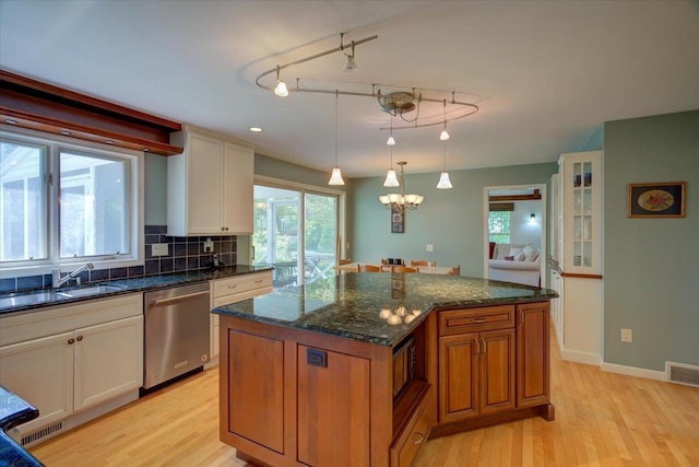 101 Everglade Dr, Madison, WI 53717 - kitchen featuring dishwasher, a sink, light wood-style floors, backsplash, and a kitchen island