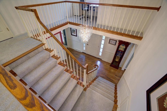 101 Everglade Dr, Madison, WI 53717 - stairway featuring wood finished floors, a chandelier, a high ceiling, and a decorative wall
