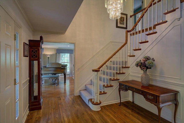 101 Everglade Dr, Madison, WI 53717 - stairway featuring hardwood / wood-style flooring, a decorative wall, a chandelier, and baseboards
