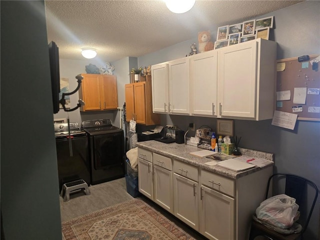 318 Frenette Dr Unit 2, Chippewa Falls, WI 54729 - kitchen featuring independent washer and dryer, a textured ceiling, light countertops, and wood finished floors