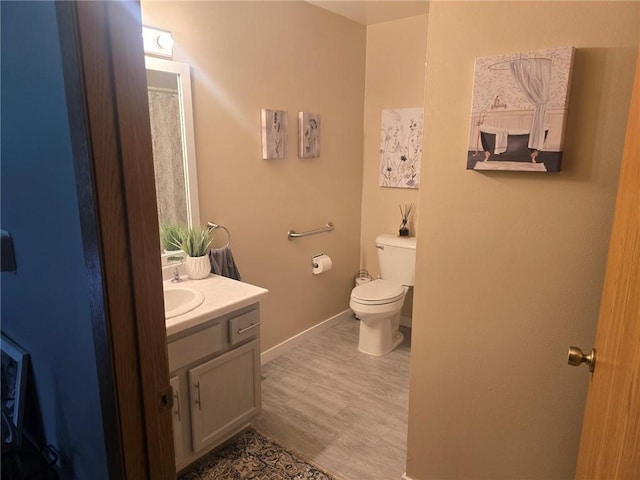 318 Frenette Dr Unit 2, Chippewa Falls, WI 54729 - full bathroom featuring vanity, toilet, wood finished floors, and baseboards